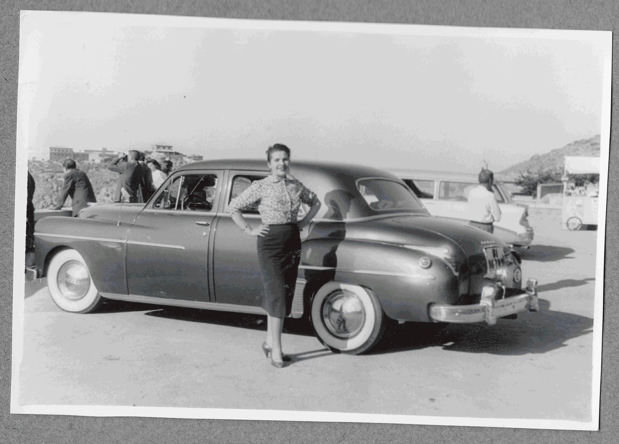 foto años 50 de mia abuela posando frente a un coche antiguo, coloreada con photoshop
